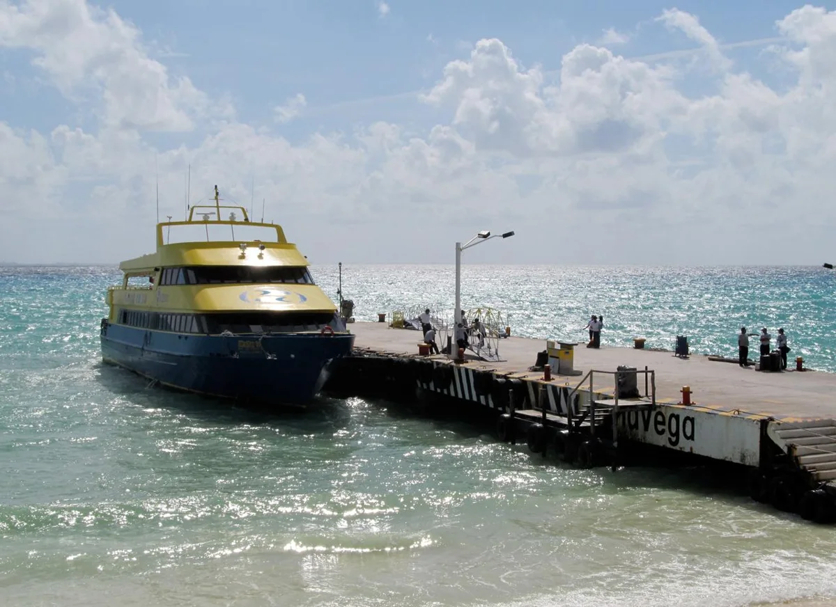 An Ultramar ferry tied up at the Playa del Carmen pier with passengers walking ashore, the ferry to Cozumel from Playa del Carmen